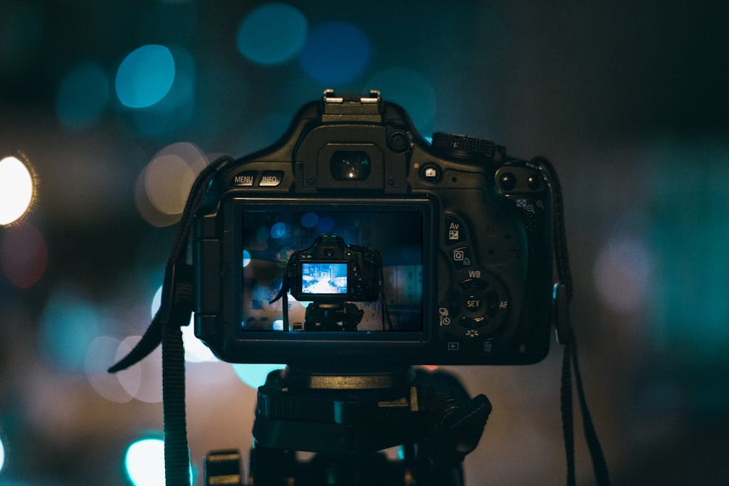 Close-up of a DSLR camera capturing a bokeh background in a dimly lit setting, illustrating night photography.