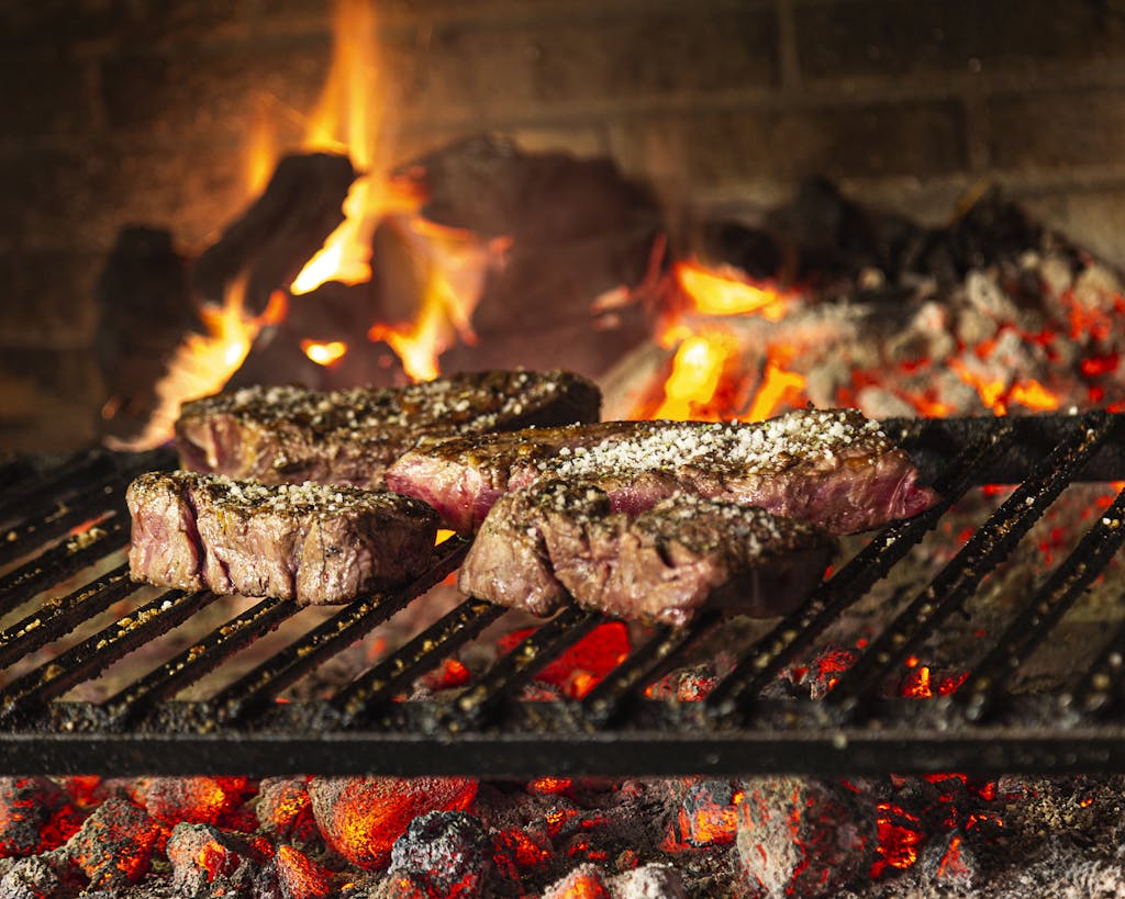 Succulent steaks grilling over hot coals and flames for a mouthwatering cookout.